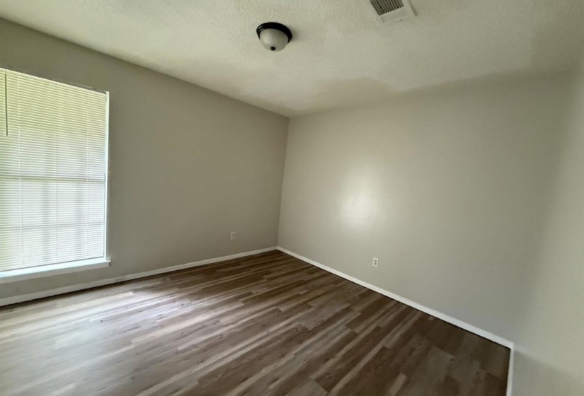 Empty room with a textured ceiling and dark wood finished floors