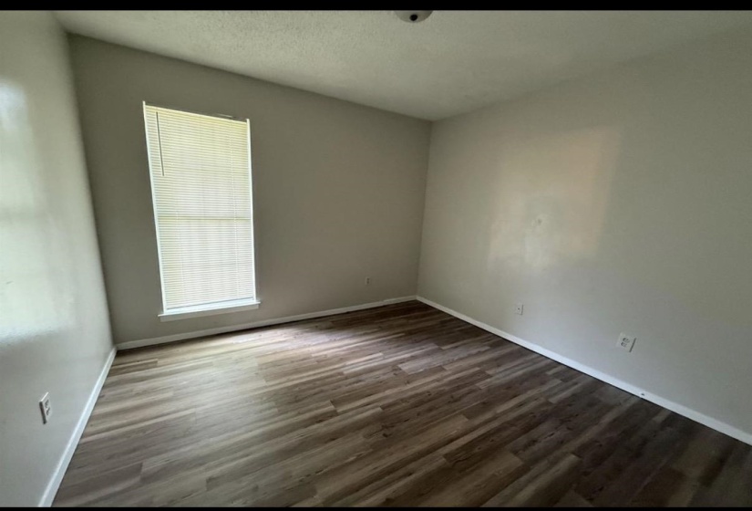 Unfurnished room featuring dark wood-style floors and a textured ceiling