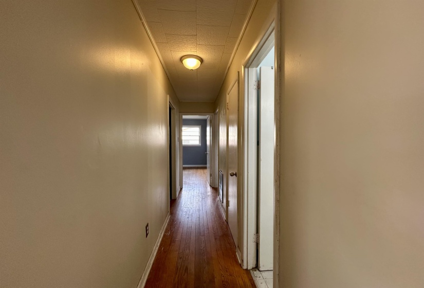 Hall featuring dark wood-type flooring and baseboards