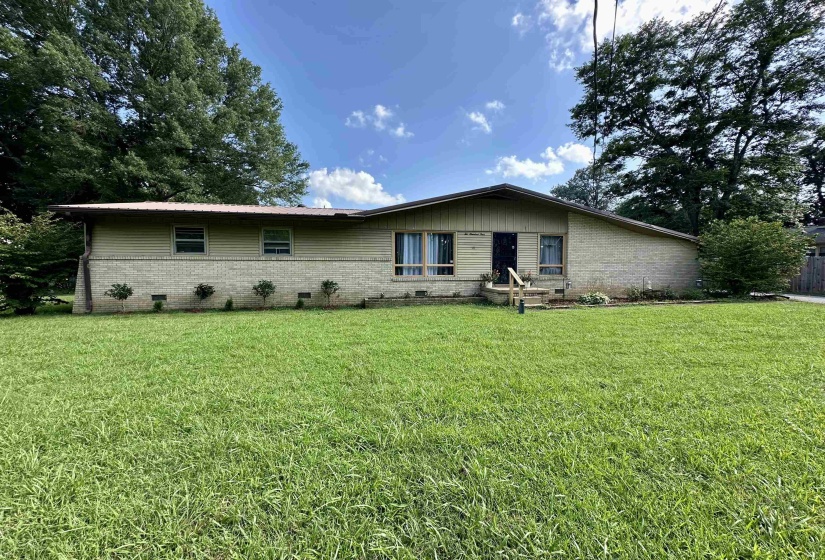 View of front facade featuring brick siding, crawl space, and a front lawn