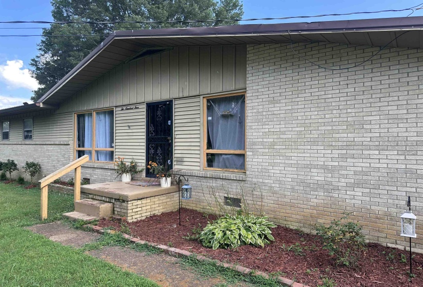 View of front facade with crawl space and brick siding