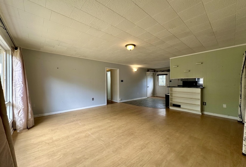 Unfurnished living room featuring baseboards and light wood finished floors