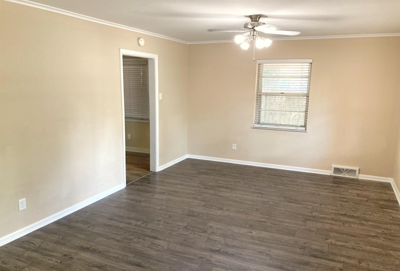 Spare room featuring ornamental molding, dark wood-style floors, and ceiling fan