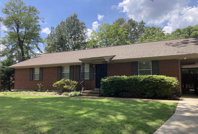 Single story home featuring roof with shingles, a front lawn, and brick siding