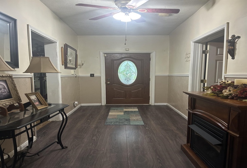 Entrance foyer featuring a textured ceiling, dark wood-style flooring, and a ceiling fan