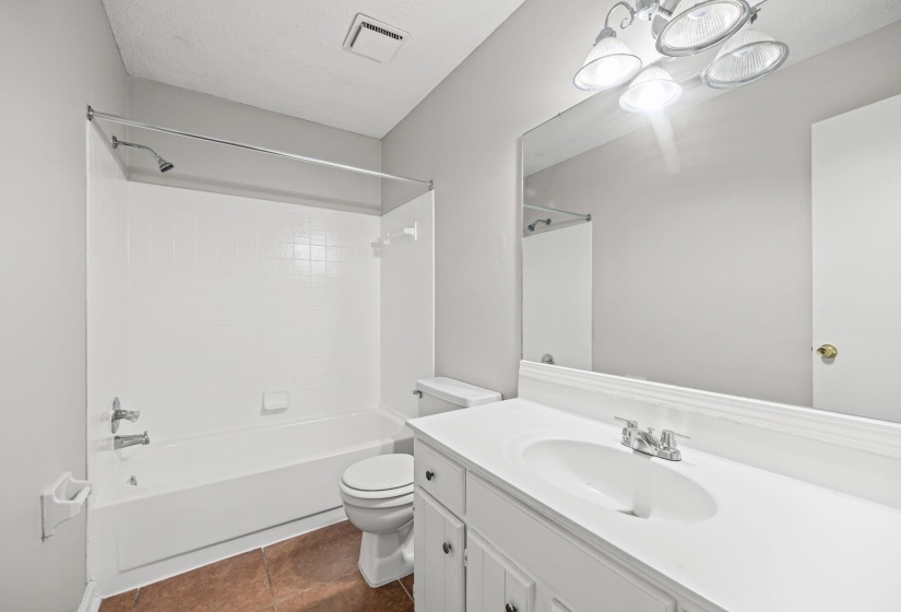 Full bathroom featuring vanity, shower / bathtub combination, dark tile patterned flooring, and a chandelier