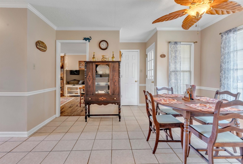 Dining space featuring crown molding, light tile patterned flooring, ceiling fan, and a textured ceiling