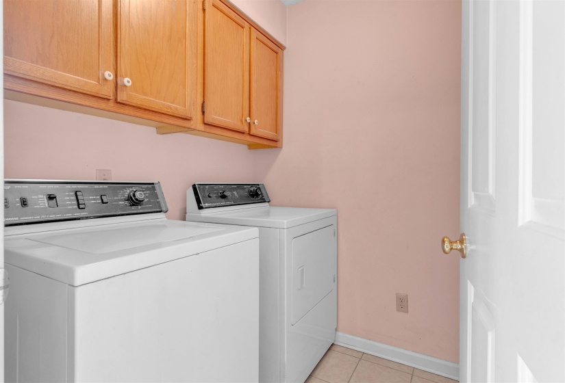Washroom featuring light tile patterned floors, cabinet space, and separate washer and dryer