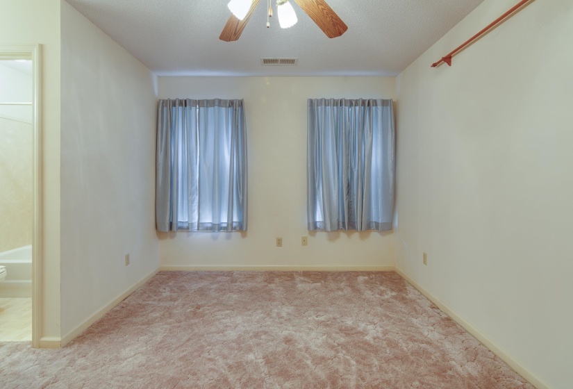 Carpeted spare room featuring ceiling fan and a textured ceiling
