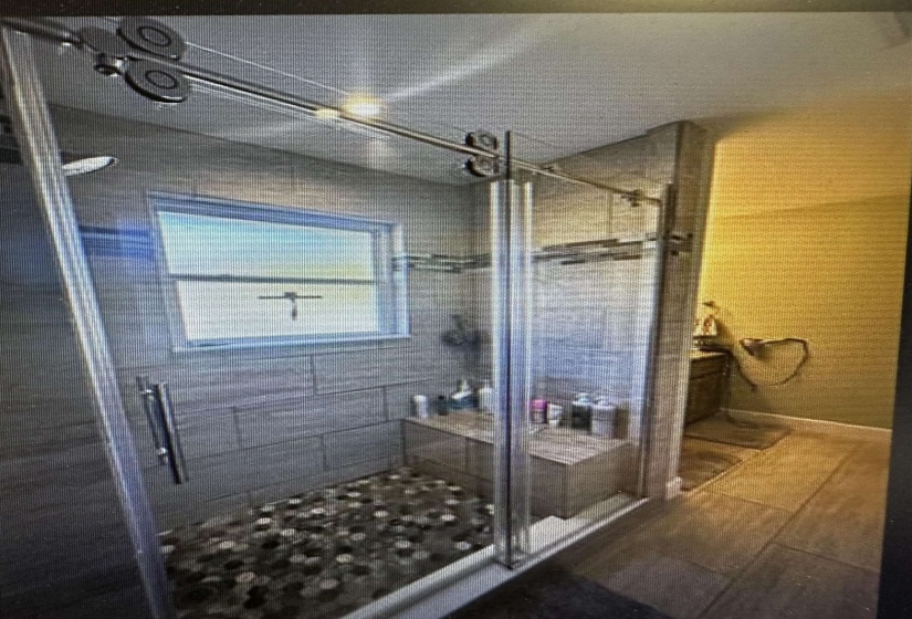 Bathroom featuring a shower stall and wood finished floors