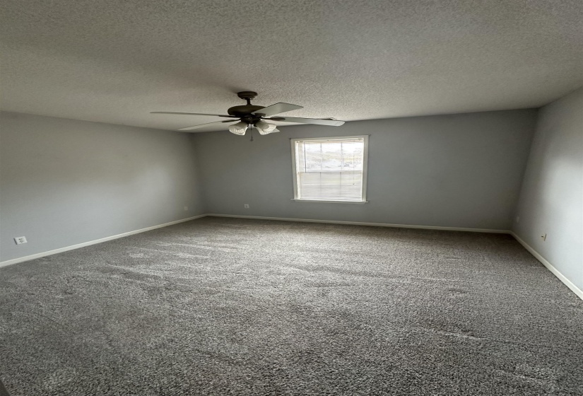 Unfurnished room with carpet flooring, a textured ceiling, and a ceiling fan