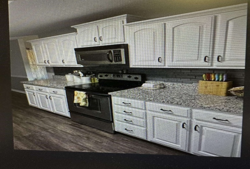 Kitchen with electric range oven, light stone countertops, white cabinetry, and dark wood finished floors