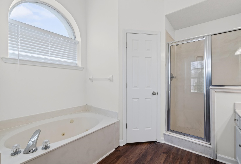 Bathroom with a shower stall, vanity, dark wood finished floors, and a whirlpool tub