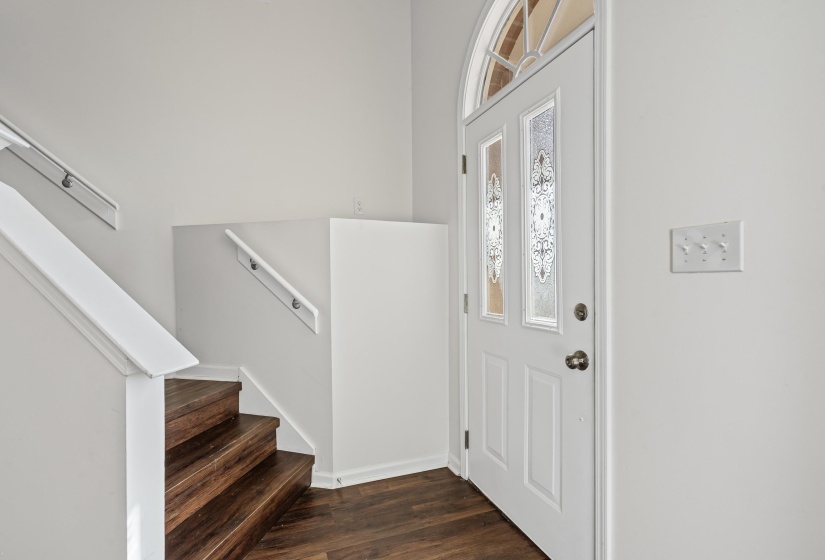 Entrance foyer with dark wood-type flooring and stairway
