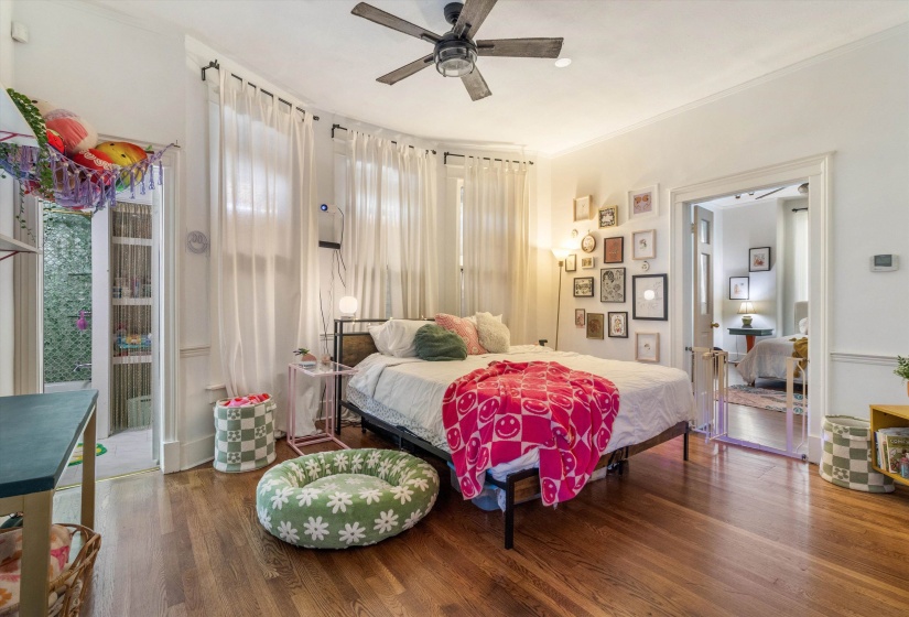 Bedroom featuring wood finished floors, ceiling fan, and ornamental molding
