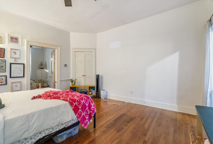 Bedroom with wood finished floors, ornamental molding, and ceiling fan
