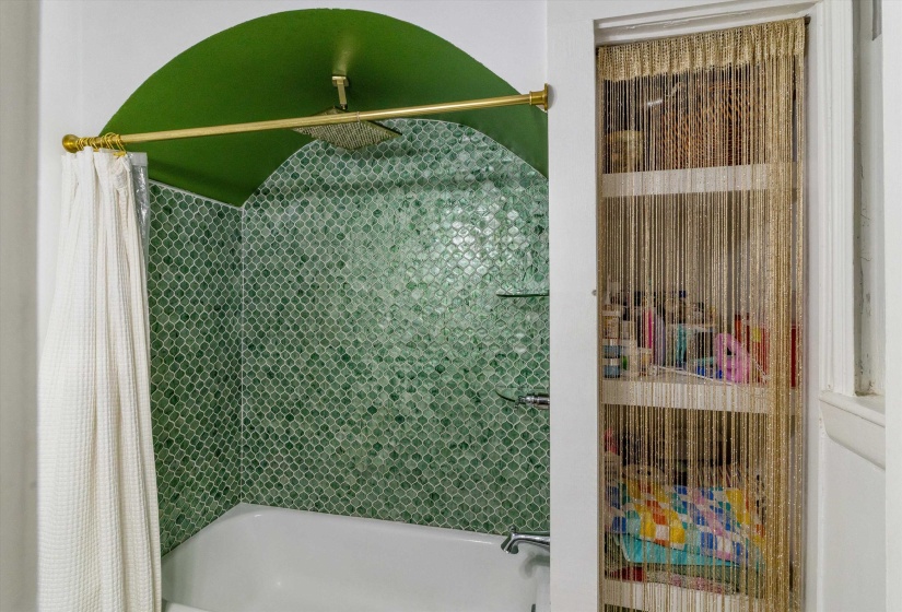 Bathroom with a combined bath / shower with rainfall shower