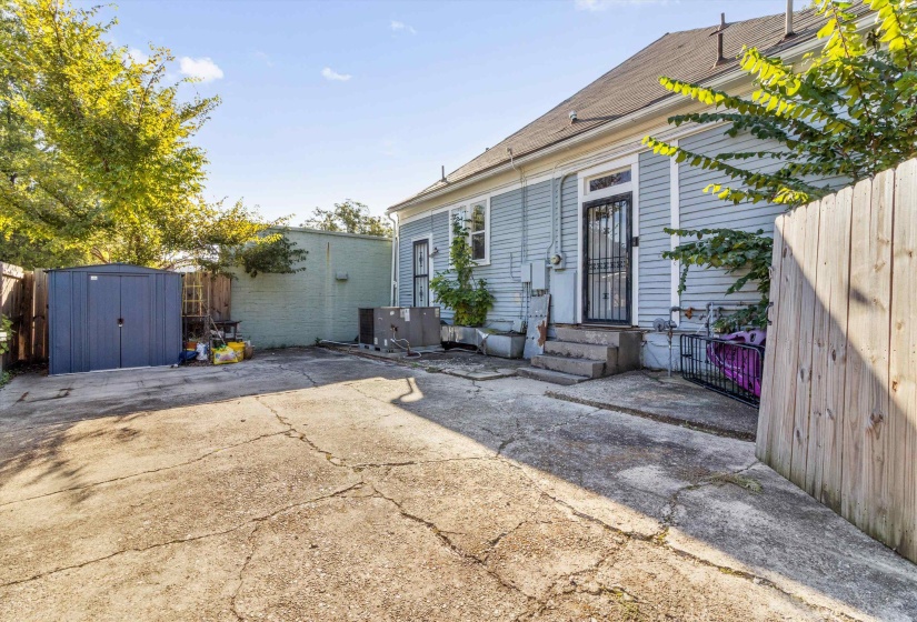 Rear view of property featuring a shed and a patio