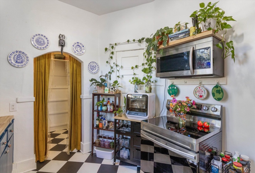 Kitchen with dark floors, appliances with stainless steel finishes, and arched walkways