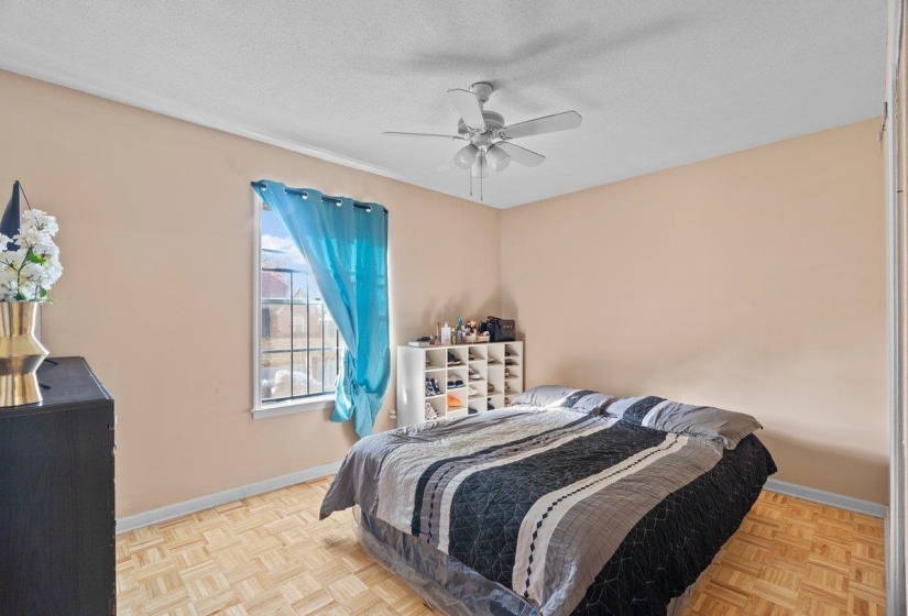 Bedroom with a textured ceiling and ceiling fan