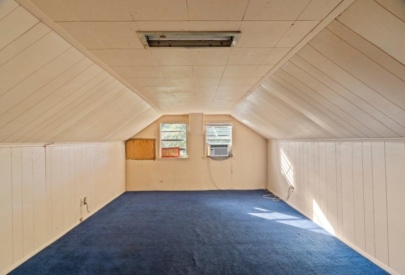Bonus room featuring wood walls, lofted ceiling, carpet floors, and cooling unit