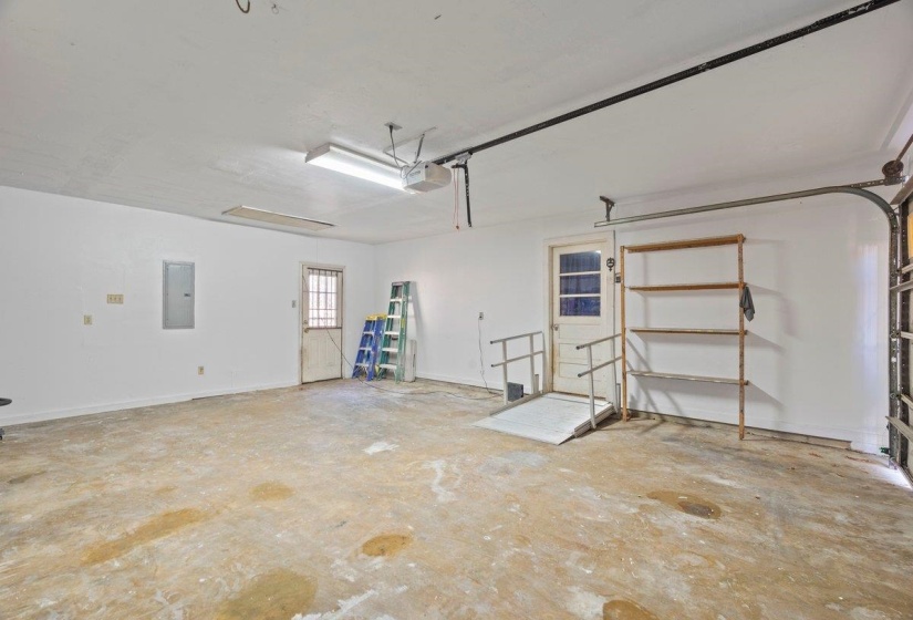 Garage featuring electric panel and a garage door opener