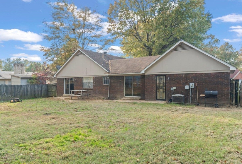 Rear view of house featuring brick siding and a patio area