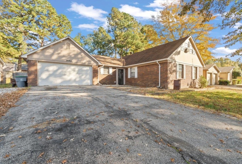 View of front of property with brick siding, asphalt driveway, and an attached garage