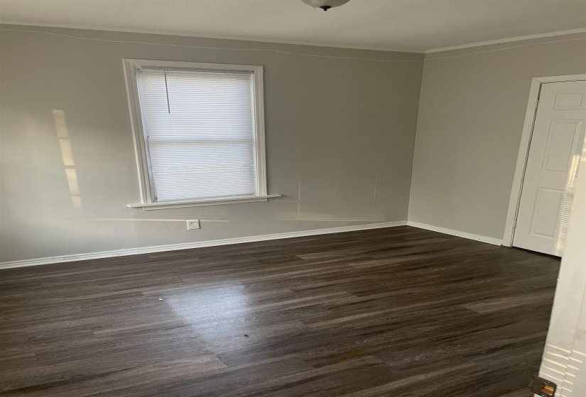 Unfurnished room featuring dark wood-type flooring and ornamental molding