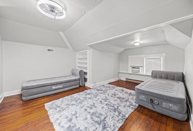 Sitting room featuring lofted ceiling, dark wood-style flooring, and a baseboard radiator