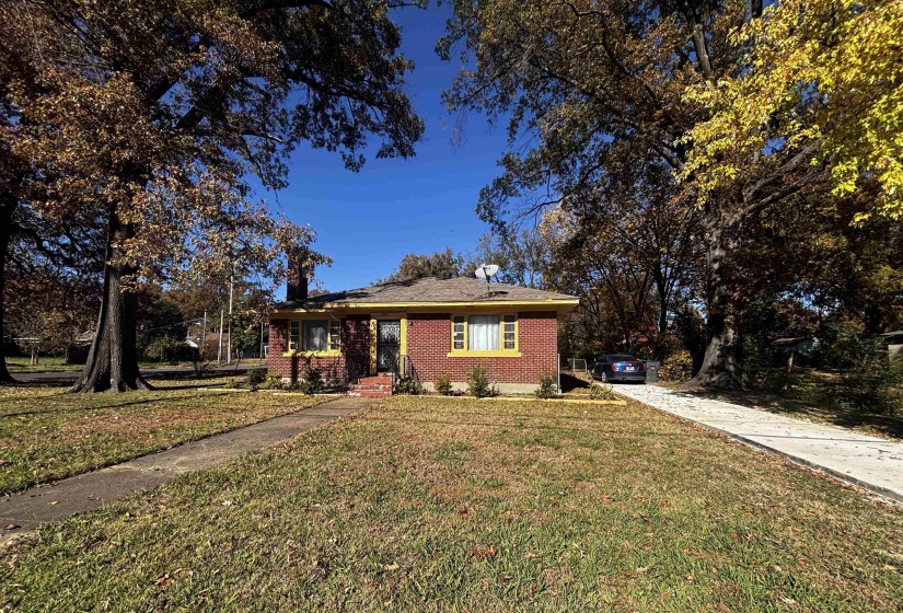 View of front of home featuring a front lawn, brick siding, and concrete driveway