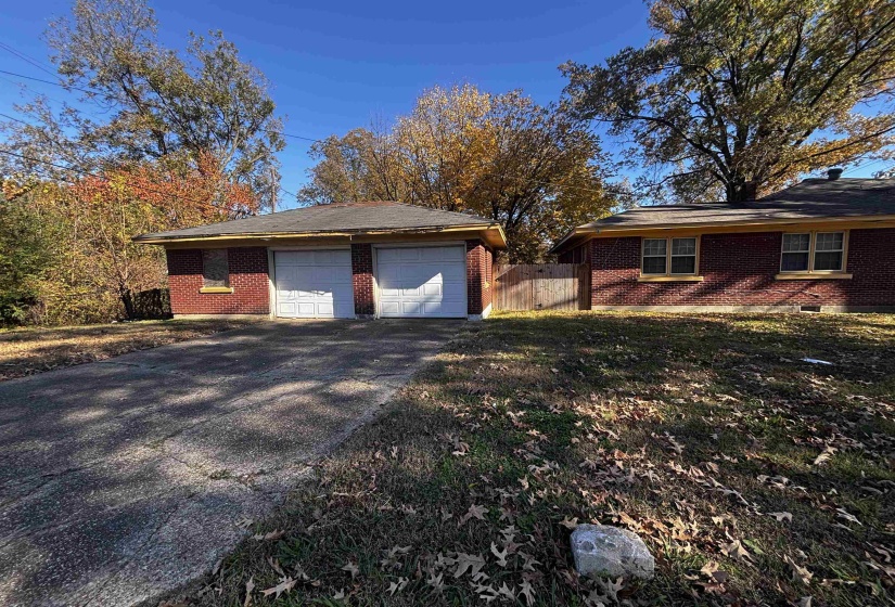 View of side of home with brick siding and an outdoor structure
