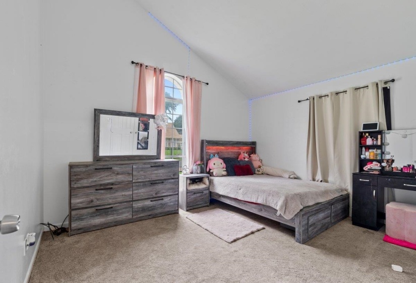 Carpeted bedroom with lofted ceiling