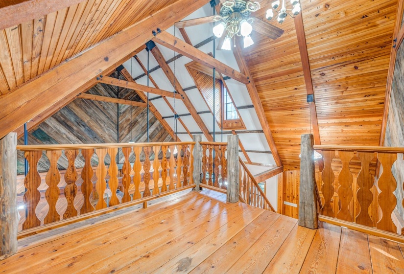 Bonus room with wooden ceiling, hardwood / wood-style flooring, wood walls, and ceiling fan