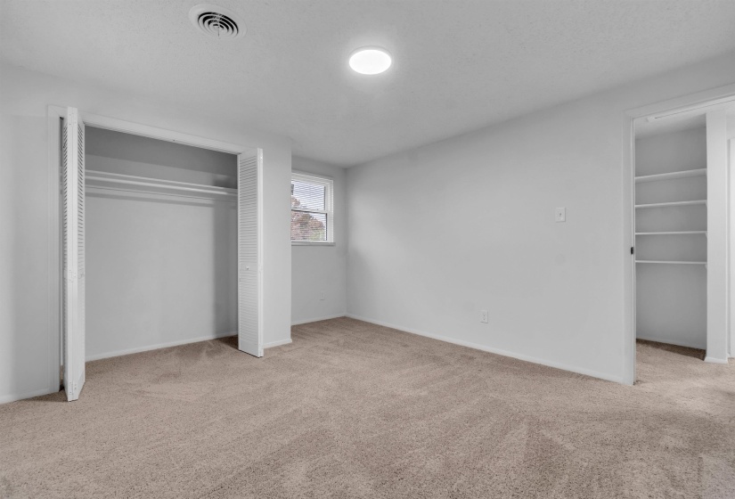 Unfurnished bedroom featuring a closet, light colored carpet, and a textured ceiling