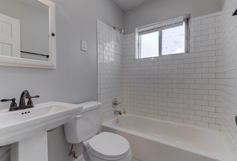 Bathroom featuring tub / shower combination and toilet