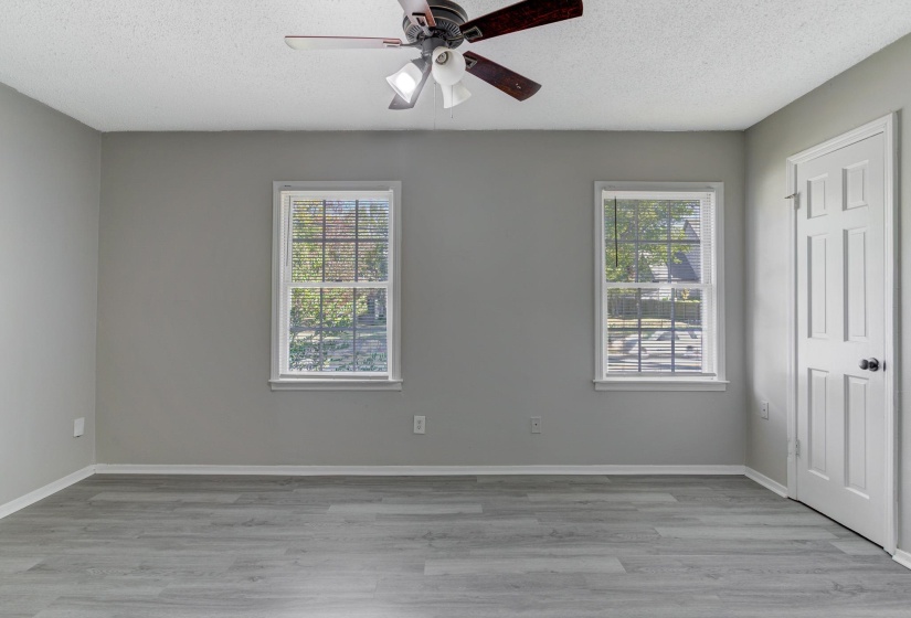 Unfurnished bedroom with light wood-style flooring, a textured ceiling, and ceiling fan