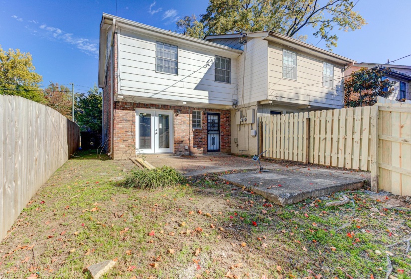 Rear view of property with a patio area, a fenced backyard, french doors, and brick siding
