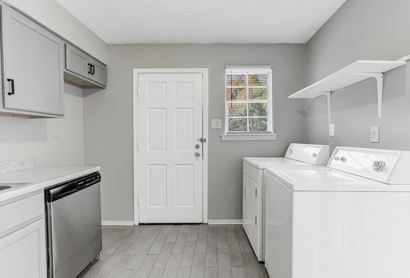 Laundry room featuring a textured ceiling, light wood-type flooring, and independent washer and dryer