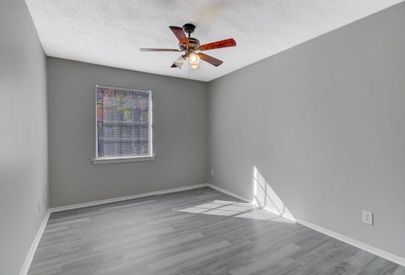 Unfurnished room featuring a textured ceiling, light wood finished floors, and ceiling fan
