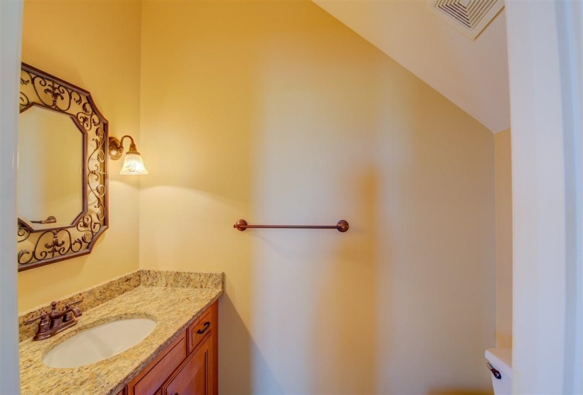 Half bathroom featuring vanity and toilet