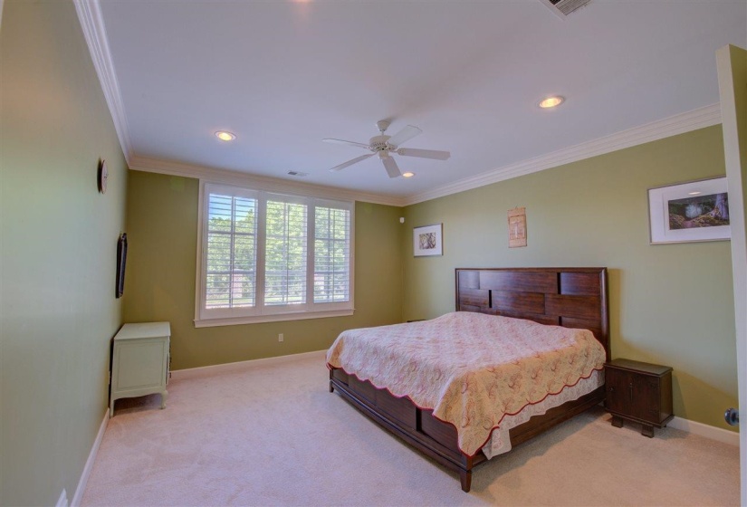 Carpeted bedroom with crown molding, recessed lighting, and ceiling fan
