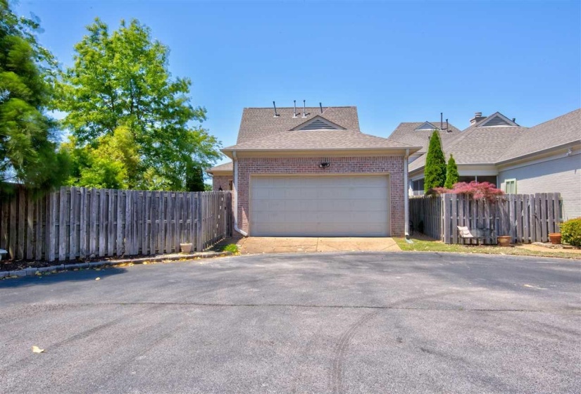 View of property exterior featuring brick siding, driveway, and a garage