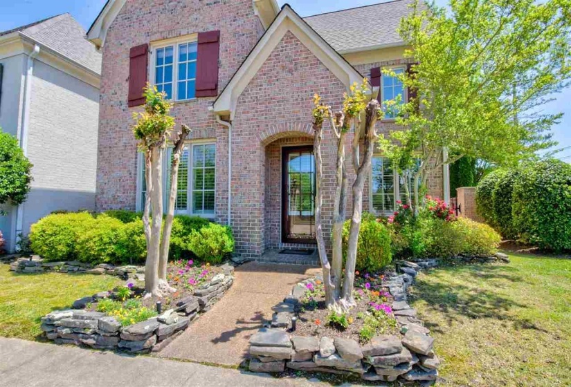 Entrance to property with brick siding and a yard