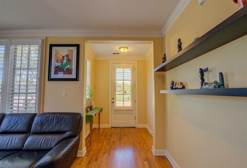 Entryway featuring ornamental molding and wood finished floors