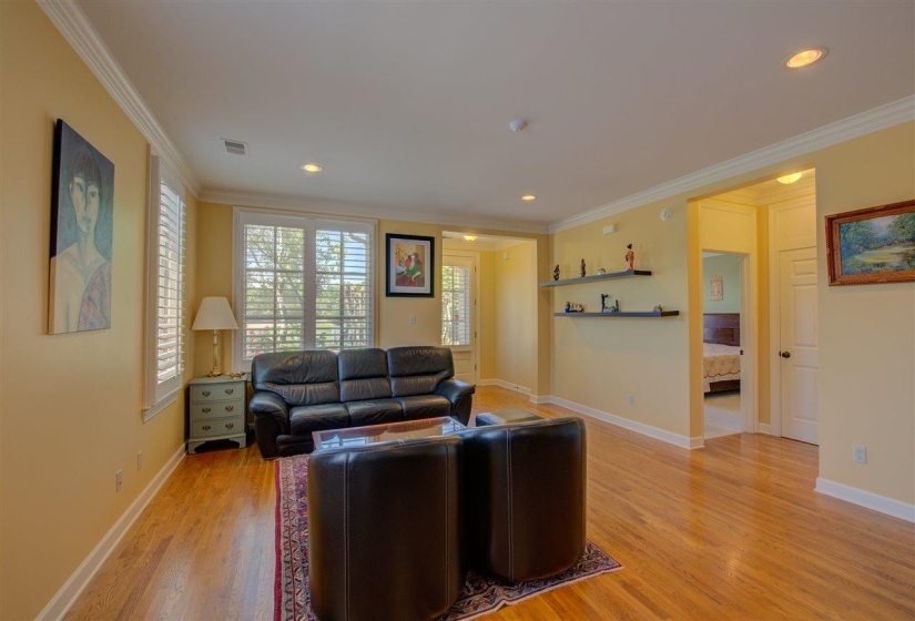 Living room featuring light wood finished floors, ornamental molding, and recessed lighting