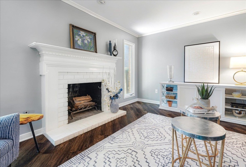 Living area with baseboards, crown molding, wood finished floors, and a fireplace