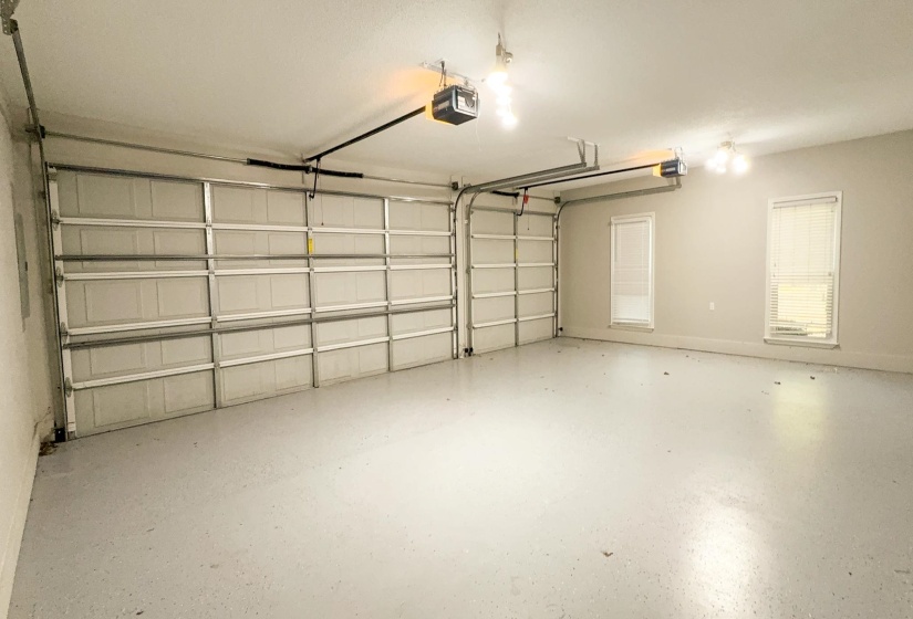 Garage featuring a garage door opener and baseboards