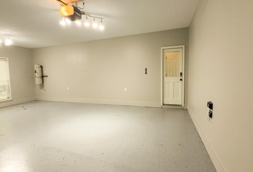 Garage with baseboards and a garage door opener