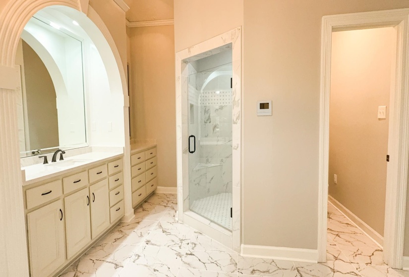 Full bathroom with vanity, a marble finish shower, light marble finish flooring, and ornamental molding